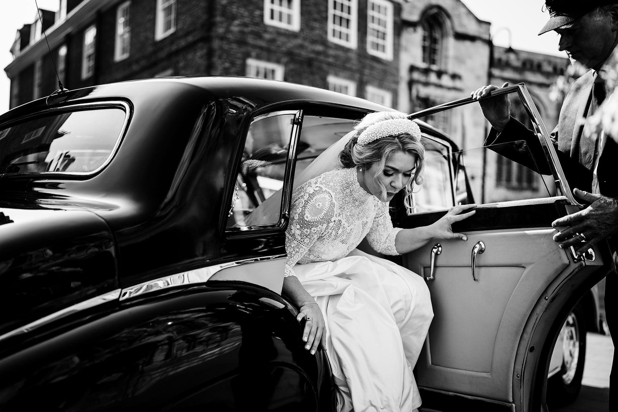 Bride stepping out of a car before her Cotswolds wedding ceremony