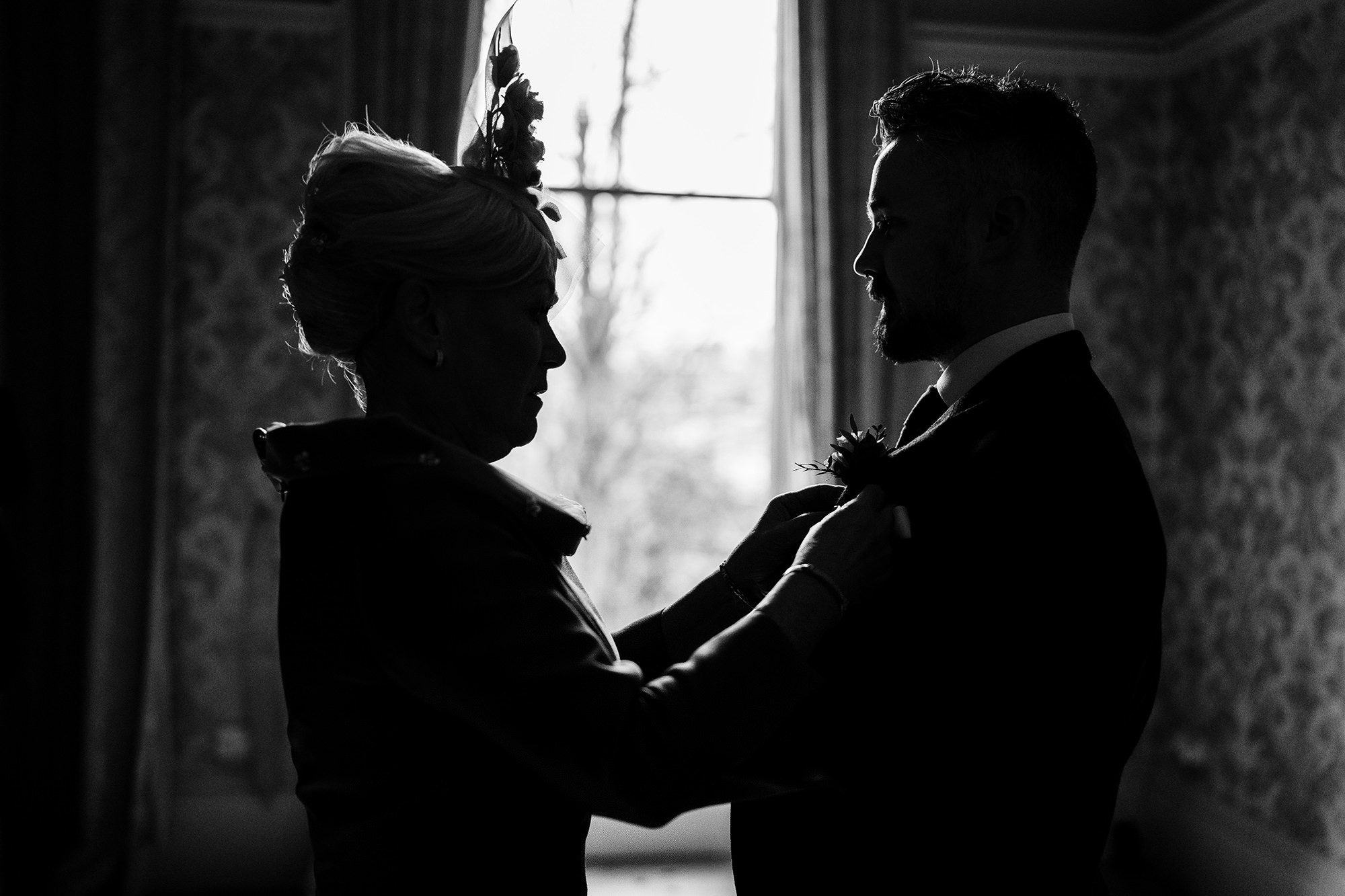 Mother helping the groom get ready on the morning of a Cotswolds wedding