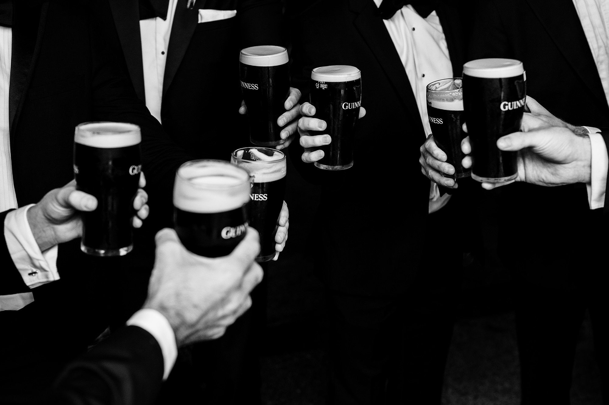 Groomsmen sharing a drink before heading to a Cotswolds wedding ceremony