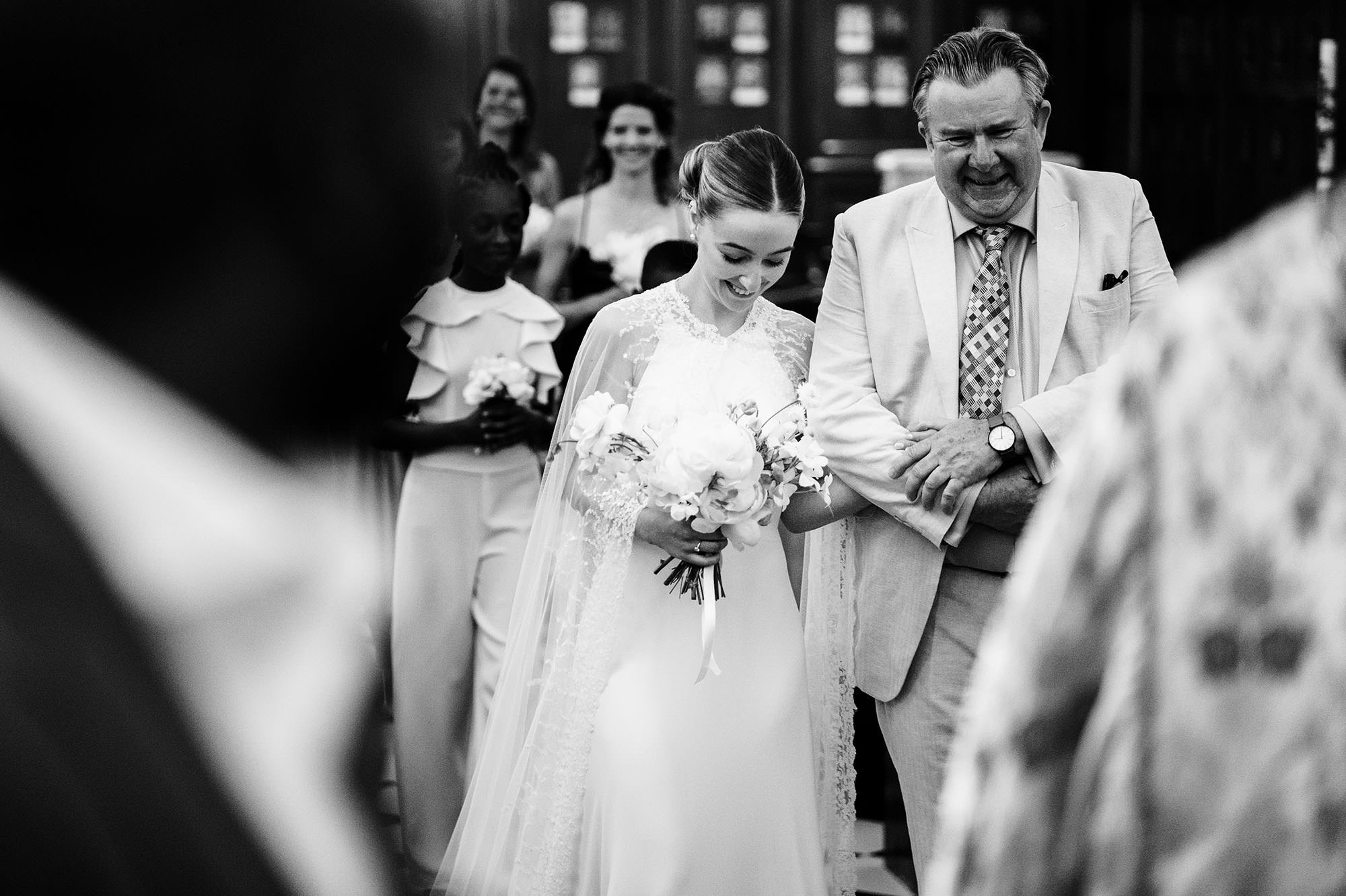 Bride walking down the aisle with her father during a Cotswolds wedding ceremony