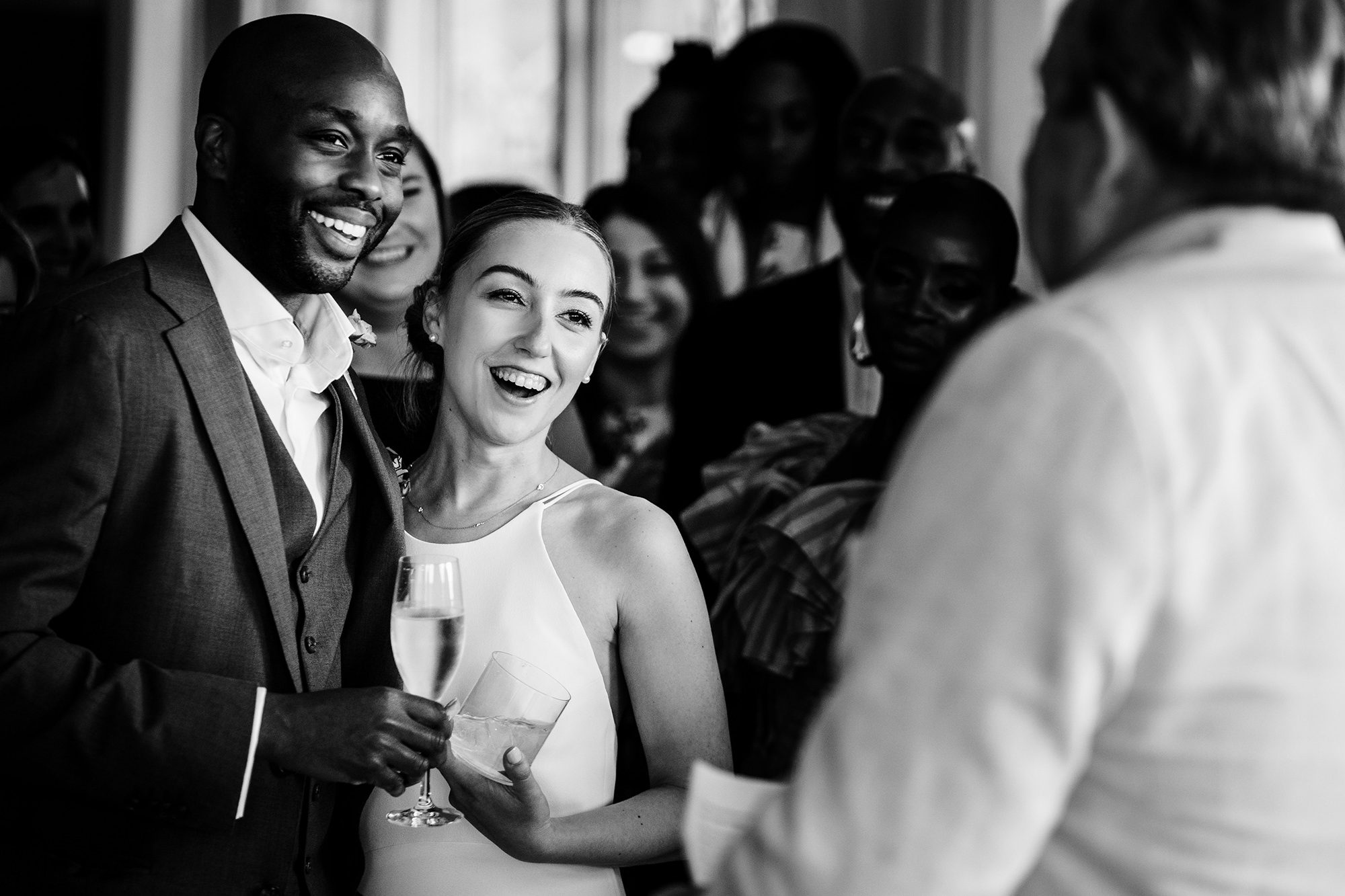 Bride and groom laughing during speeches at a Cotswolds wedding reception